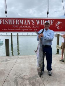 Mike Hagee holding a fish the size of him after deep sea fishing in Port Aransas.